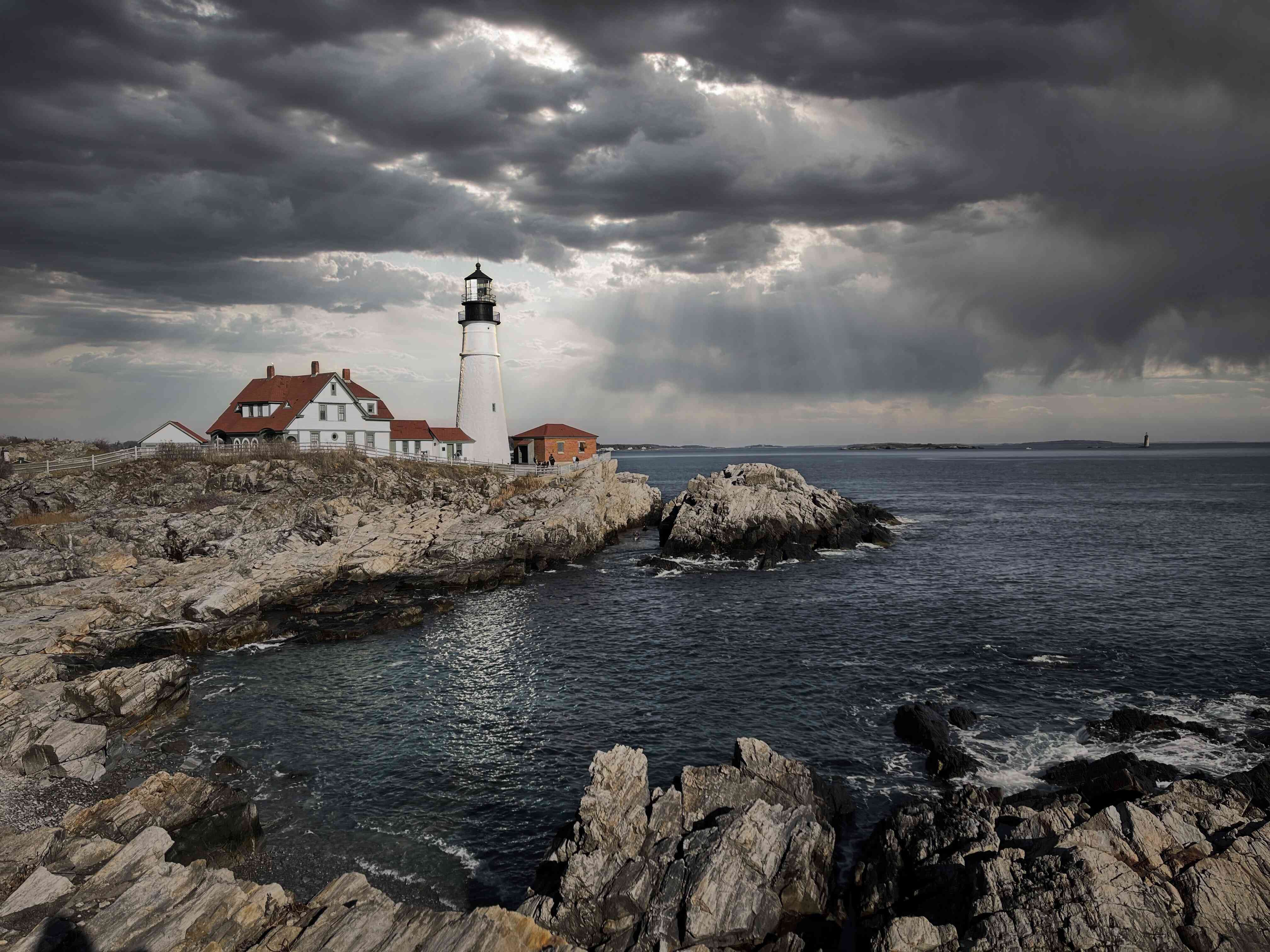 Light house on the shore with waves crashing into rocks